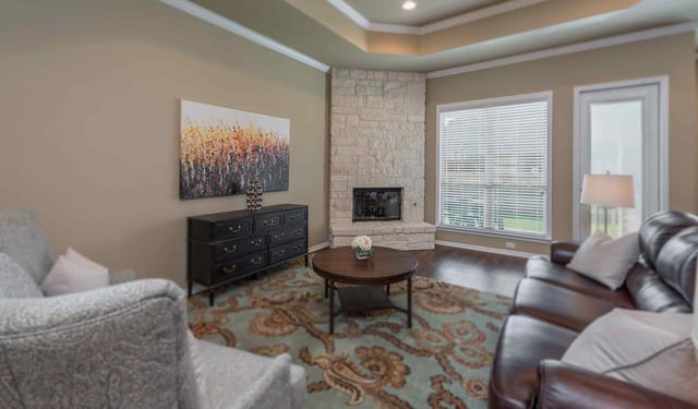corner fireplace in family room with recessed ceiling